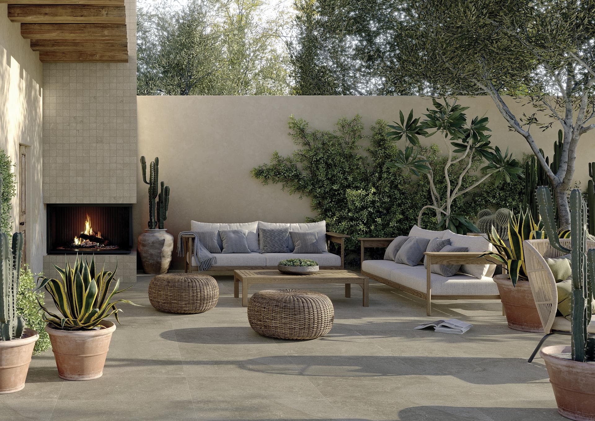 Outdoor patio with fireplace and stone-effect floor Patio with lit fireplace, sofas and rattan poufs on dark beige stone-effect floor with 30x30 mosaic