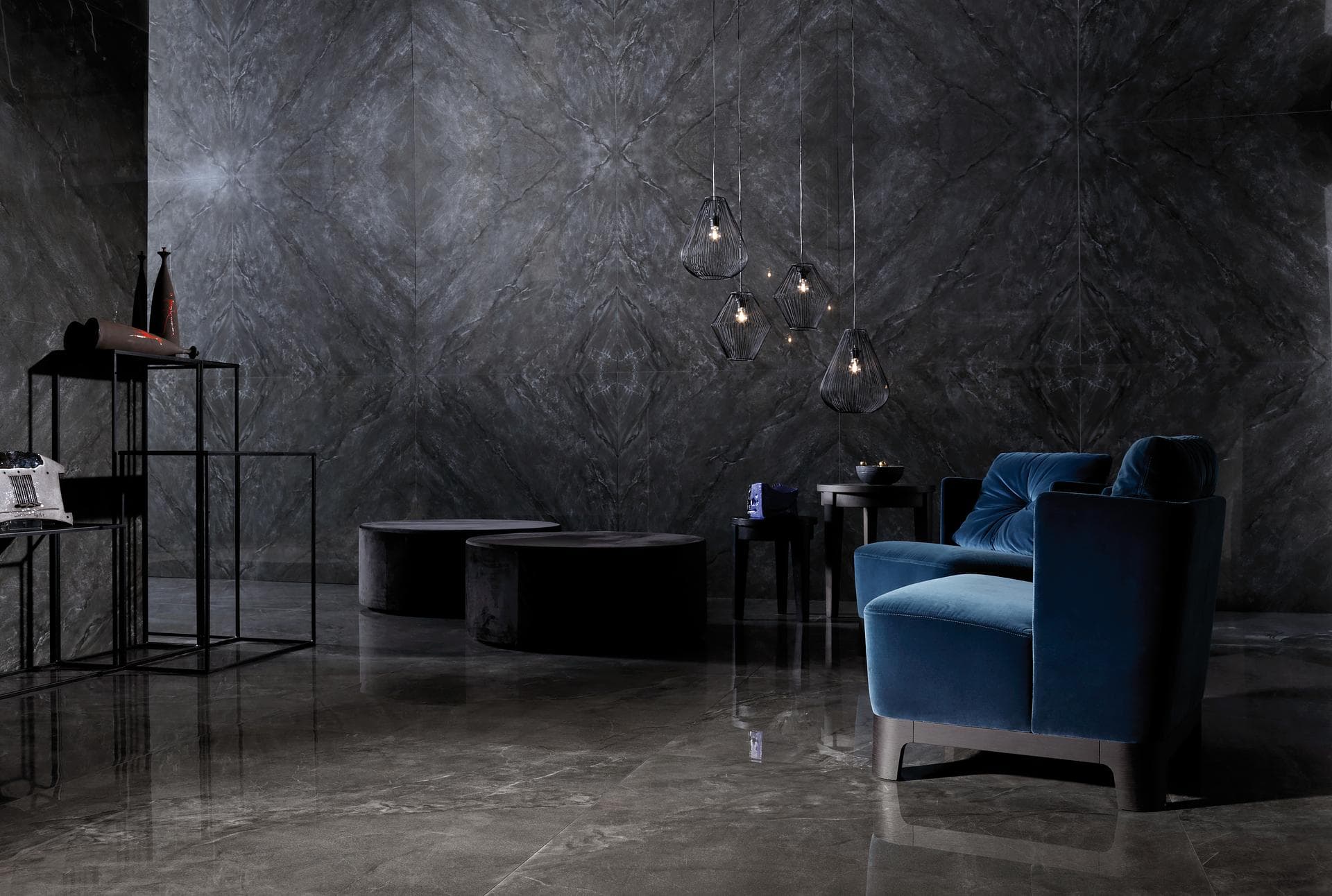 Lounge area in dark grey marble-effect tiles Indoor space with book-matched dark grey polished marble-effect tiles on the wall and reflective floor