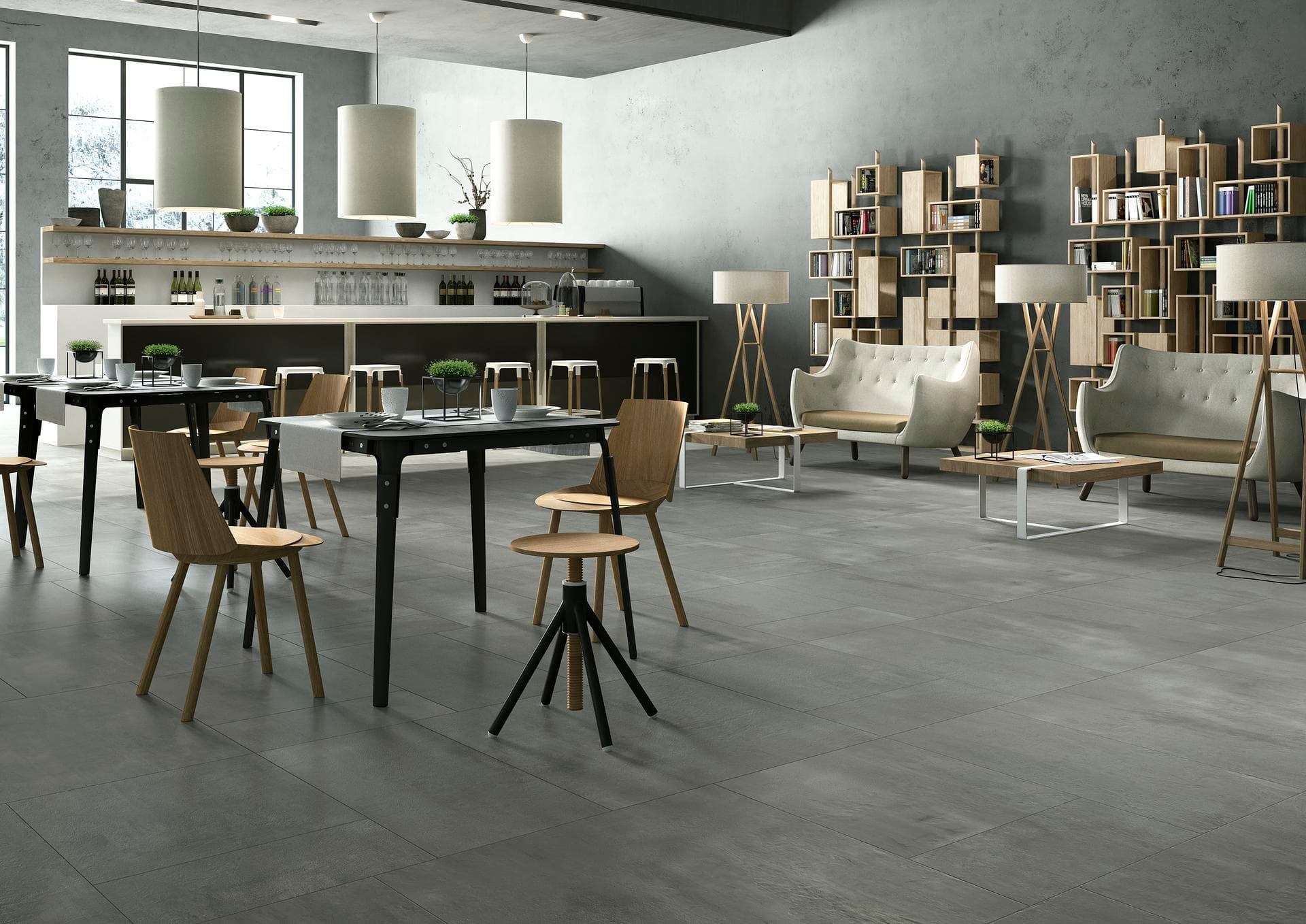Cafetería con suelo efecto cemento gris Cafetería con barra, mesas y sofás, suelo de gres efecto cemento gris mate en grandes losas