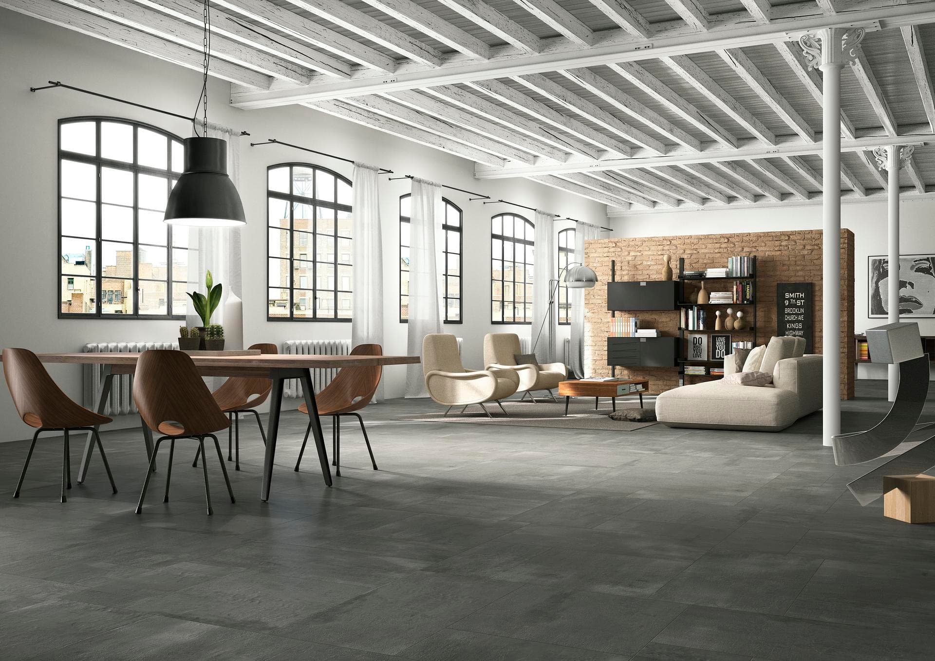Loft with dining and living area, concrete-effect floor Open loft with white beams, dining area and sofa on dark grey matt concrete-effect floor tiles