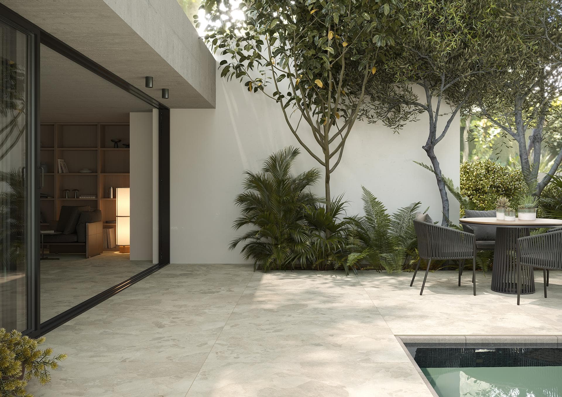 Outdoor patio with pool and dining area Patio with pool and dining table paved in matt beige stone-effect porcelain 60x120