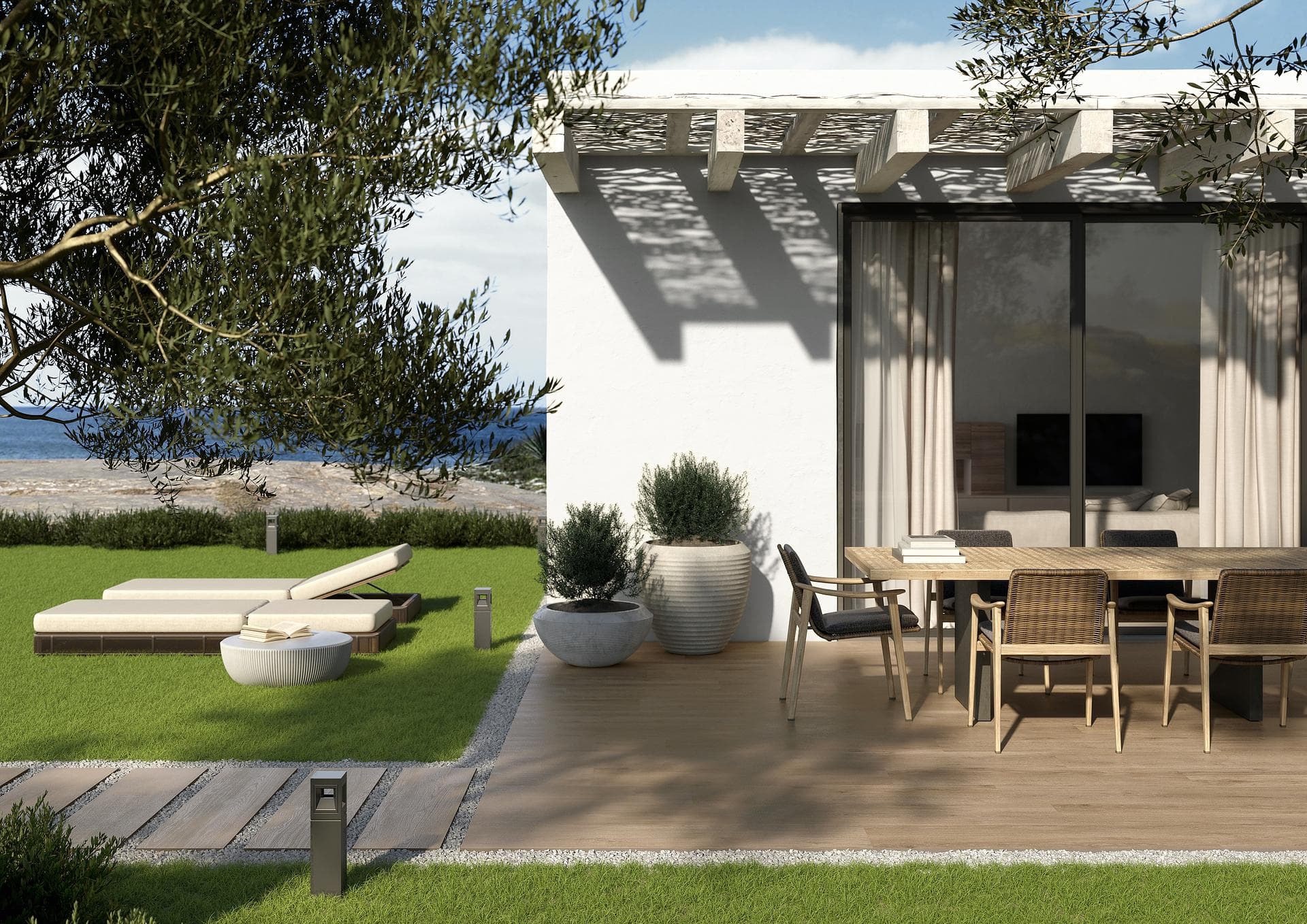 Outdoor terrace with wood-effect flooring Outdoor terrace paved with hazel wood-effect 30x120 tiles, dining table, pergola and lawn facing the sea