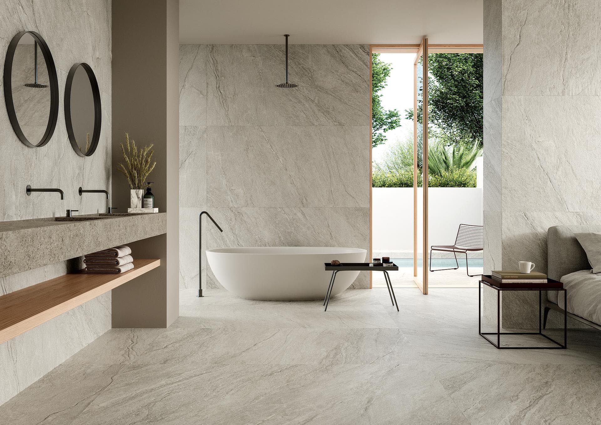 Baño con bañera y superficies efecto piedra beige Baño con bañera exenta y porcelánico efecto piedra beige mate en suelo y paredes, con salida al patio