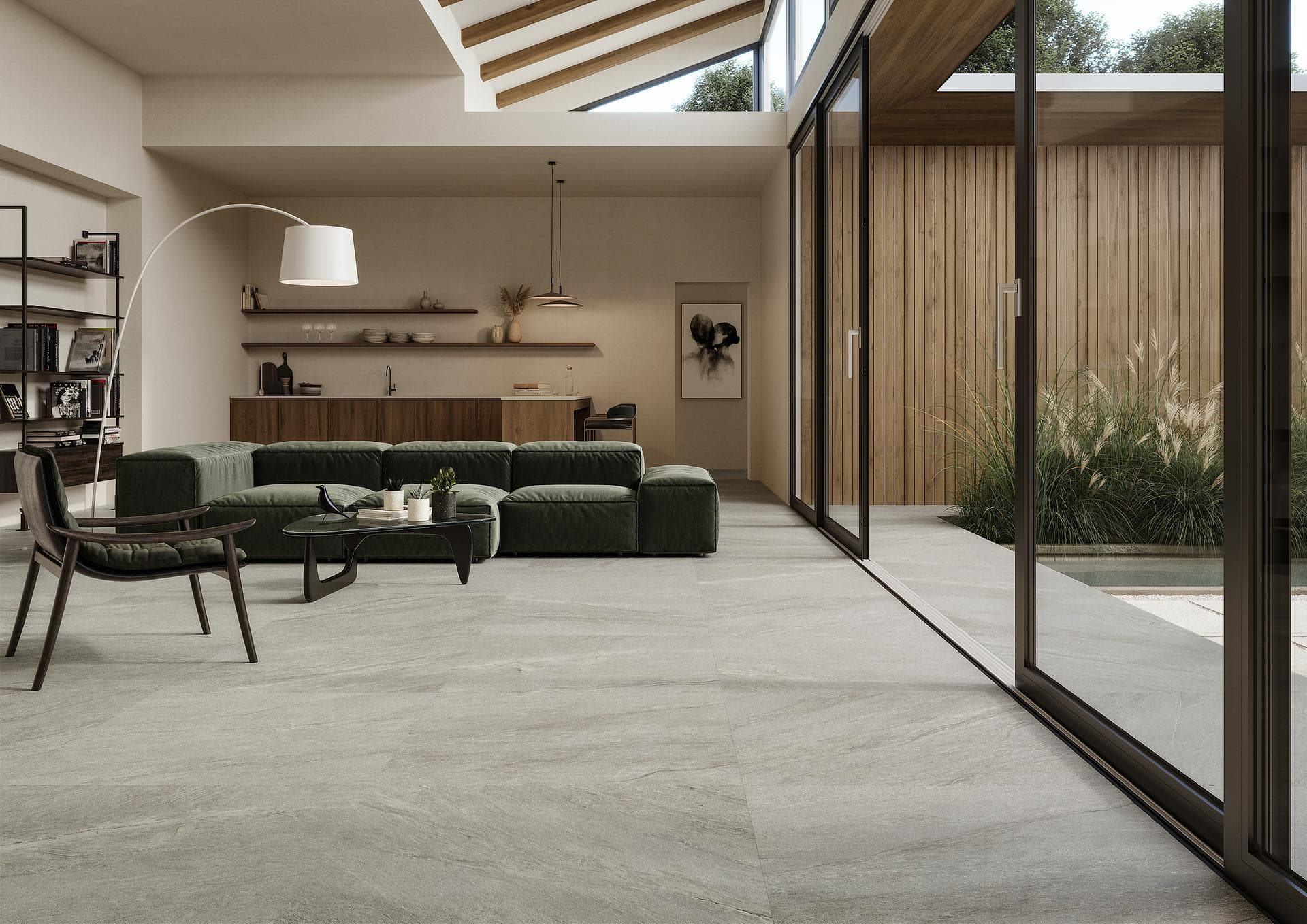 Living room with grey stone-effect floor Living room with green sofa and sliding glass walls, matt grey stone-effect 90x90 floor tiles