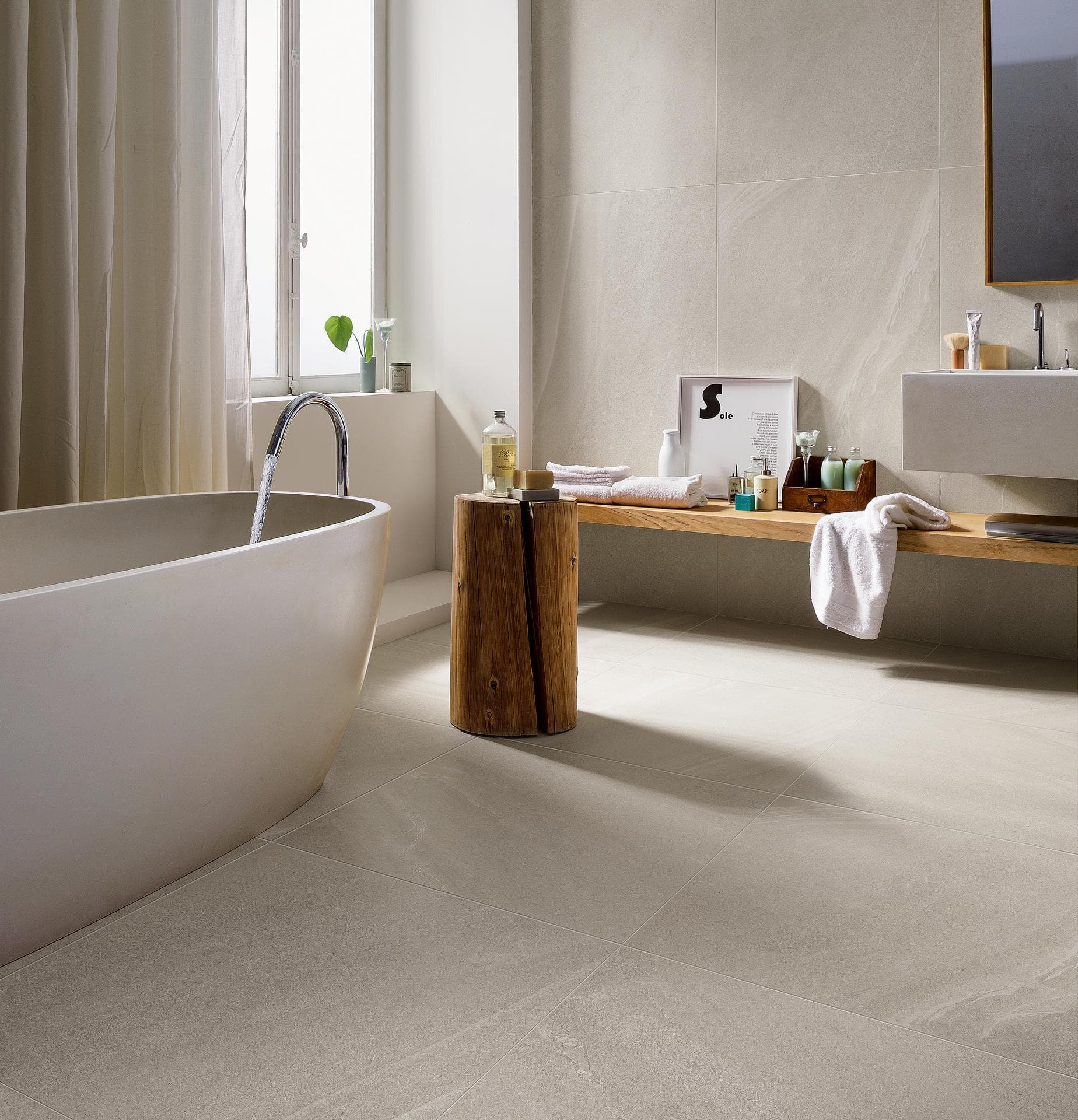 Bathroom with tub and white stone-effect tiles Bathroom with freestanding tub, matt white stone-effect tiles on floor and wall and a wooden shelf