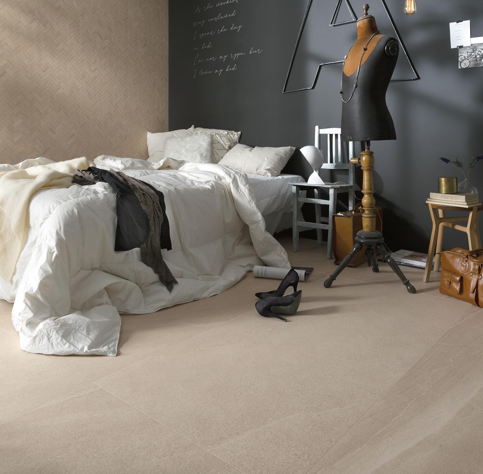 Bedroom with beige stone-effect porcelain Bedroom with beige stone-effect floor tiles and herringbone mosaic wall beside a dark grey painted wall