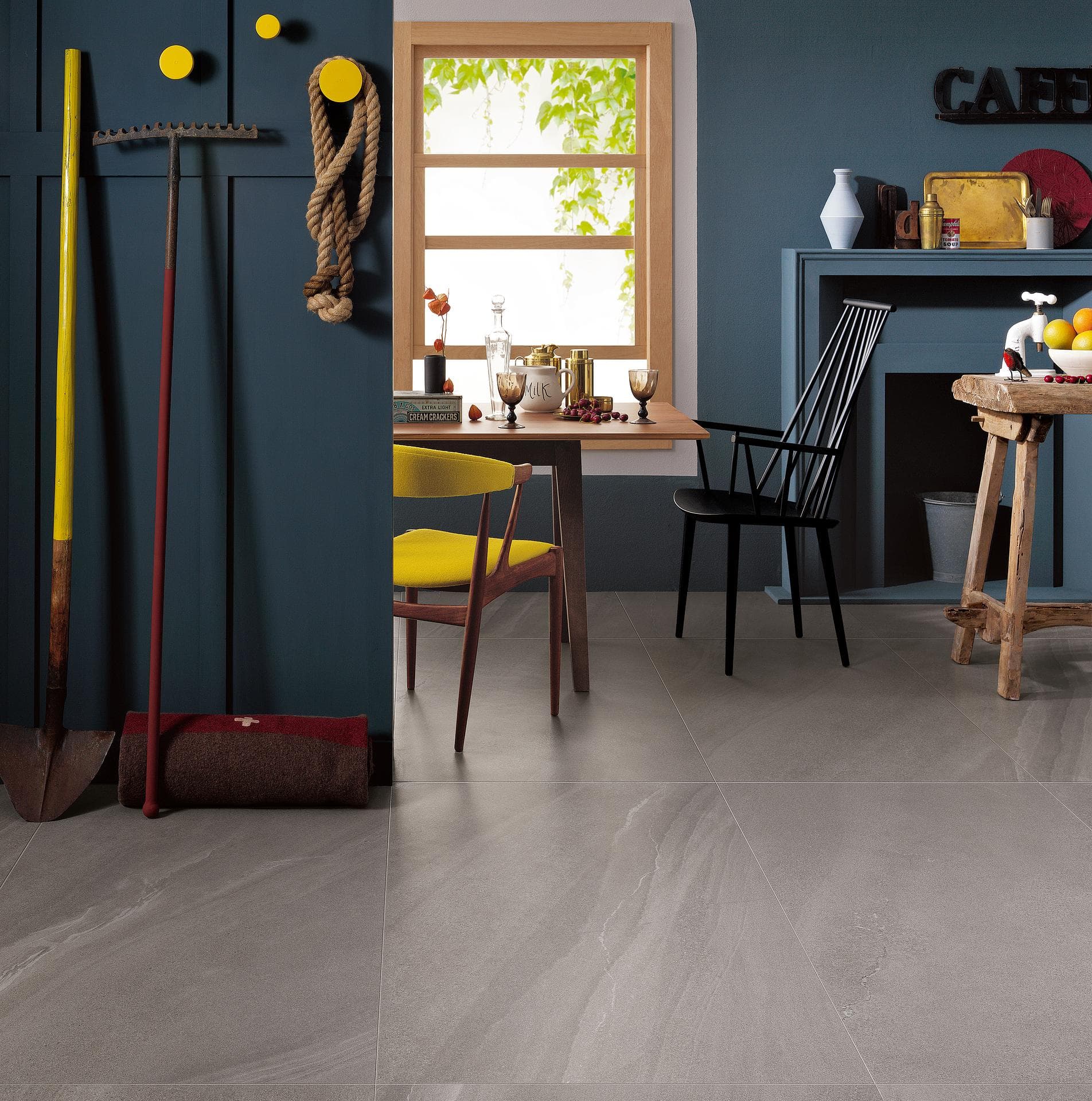 Dining corner with grey stone-effect floor Dining area with blue walls, wooden table and grey matt stone-effect large-format floor tiles